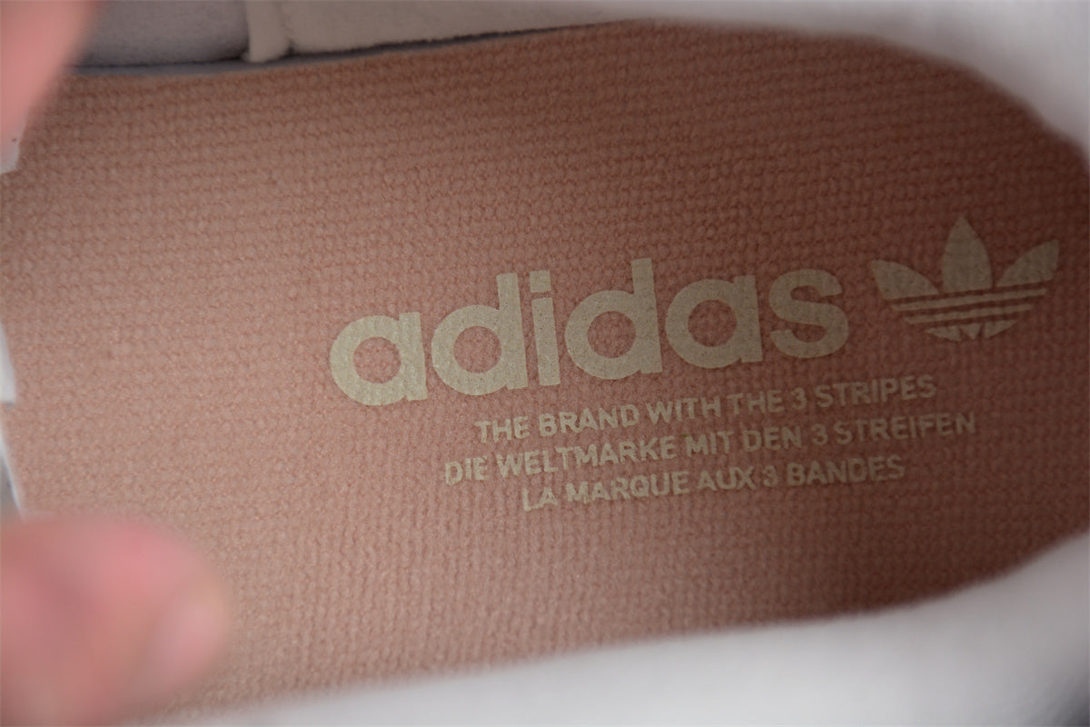 Close-up of Adidas logo on a brown textured surface