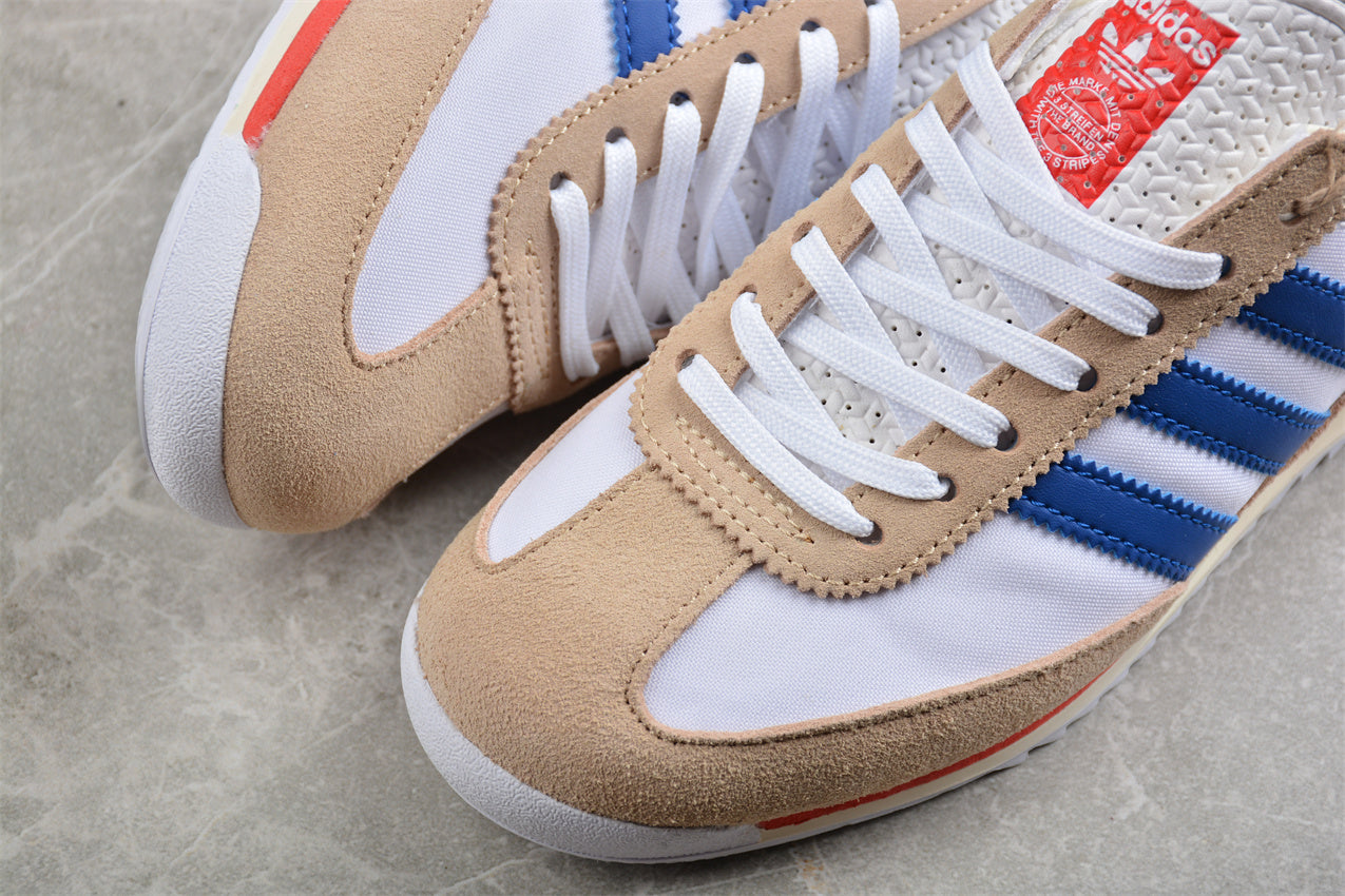 Beige and white sneakers with blue stripes and red label on a gray surface