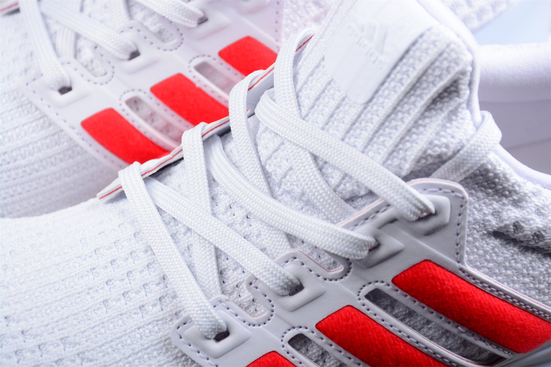 Close-up of a white sneaker with red accents and visible branding.