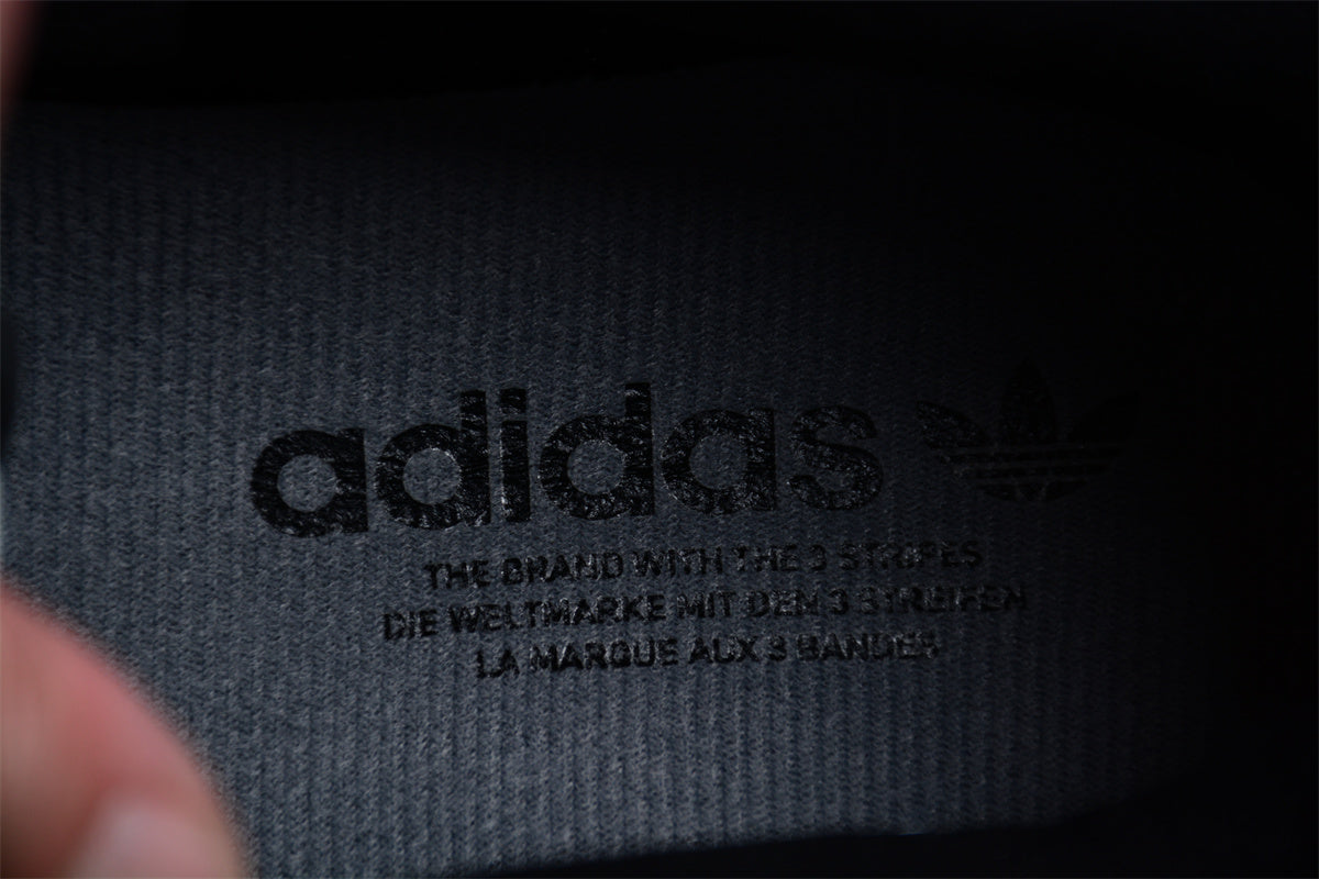 Close-up of Adidas logo and text on a dark fabric background