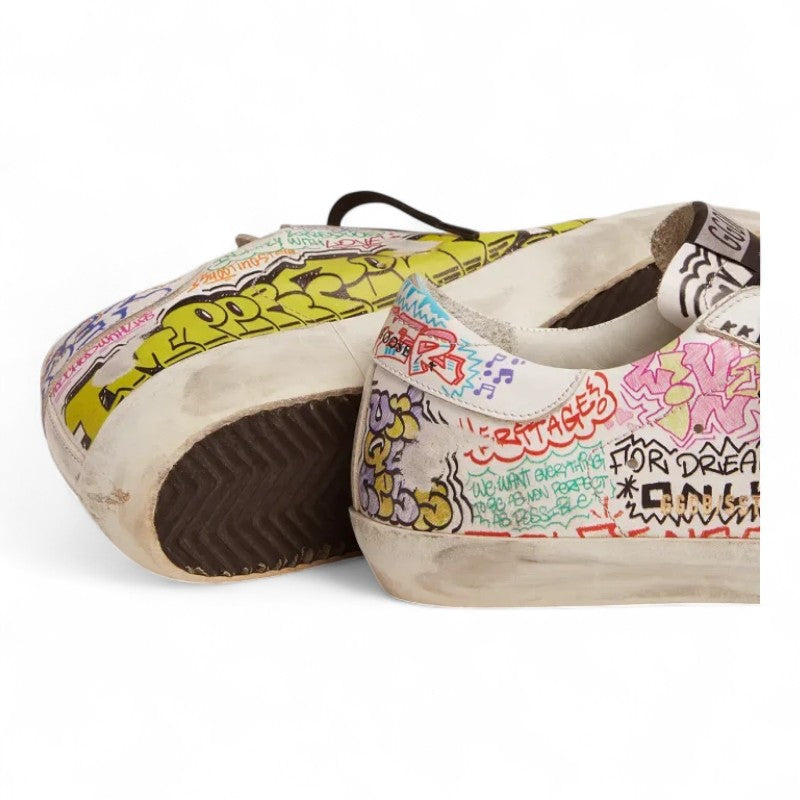 The Super-Star sneakers feature a white leather upper adorned with a vibrant multicolored graffiti print - Best Reps Website 2025