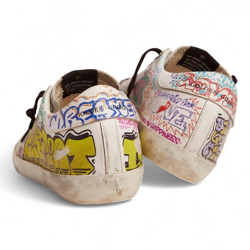 The Super-Star sneakers feature a white leather upper adorned with a vibrant multicolored graffiti print - Best Reps Website 2025